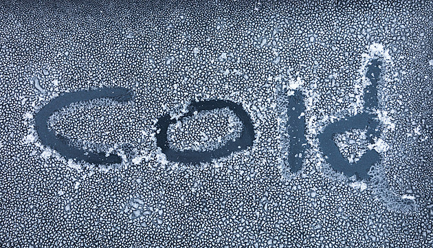 The word cold written in frost on a car
